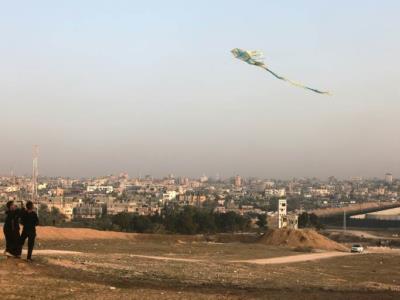 Niños palestinos de Rafah jugando a elevar cometas en el lado opuesto de la frontera