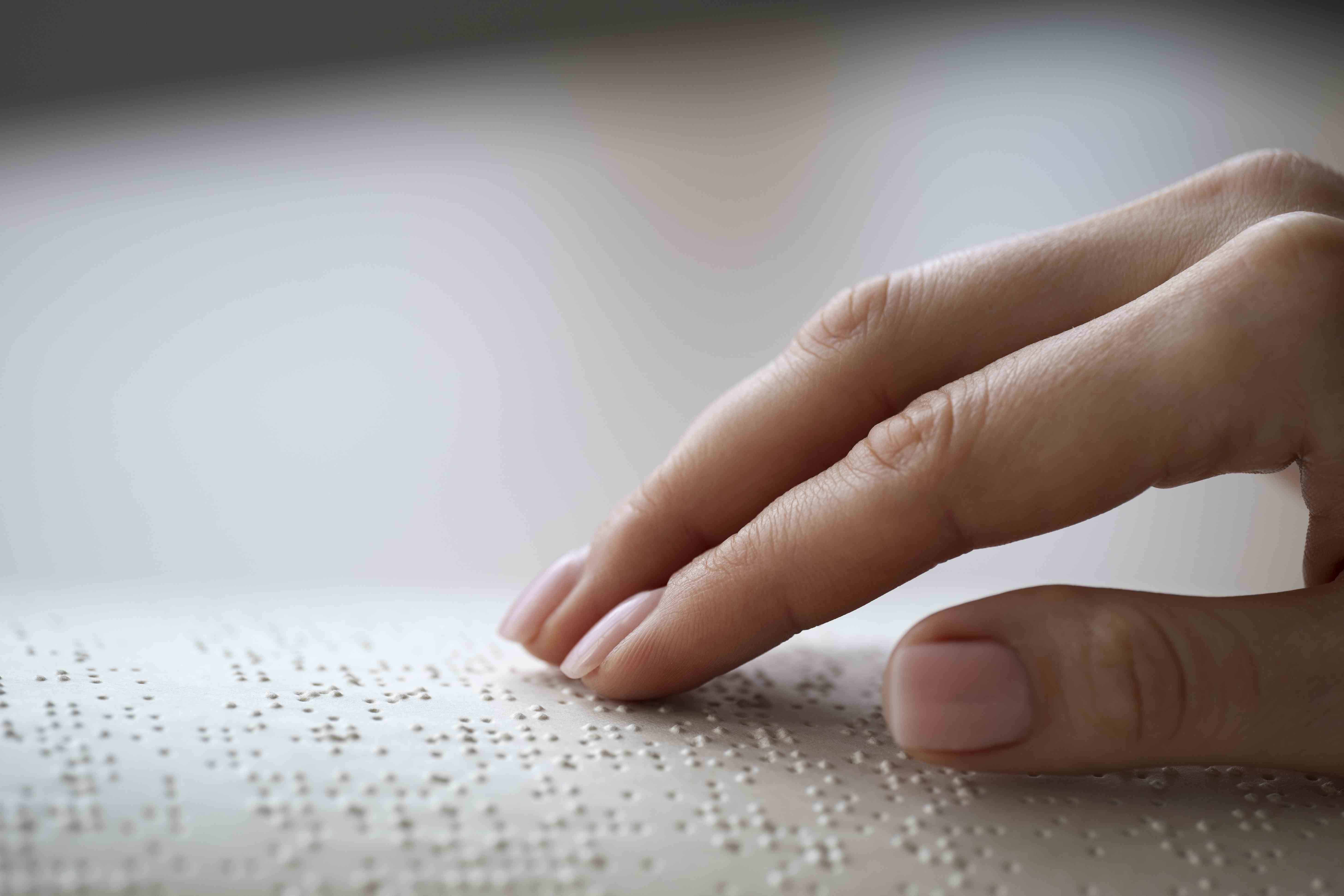 Imagen de una persona leyendo a través del Sistema Braille.