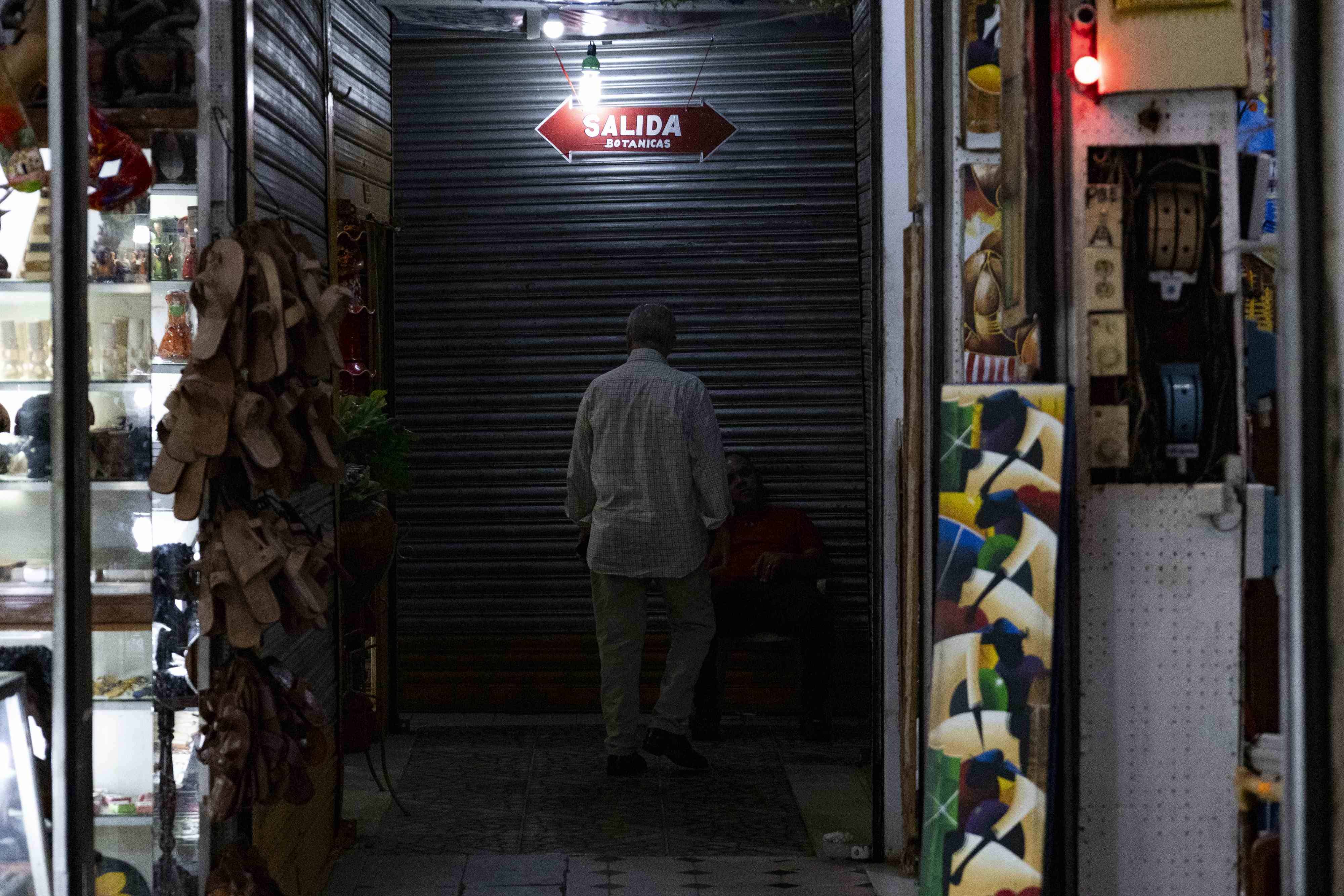 Un cartel de salida, iluminado por una bombilla, en el mercado Modelo.