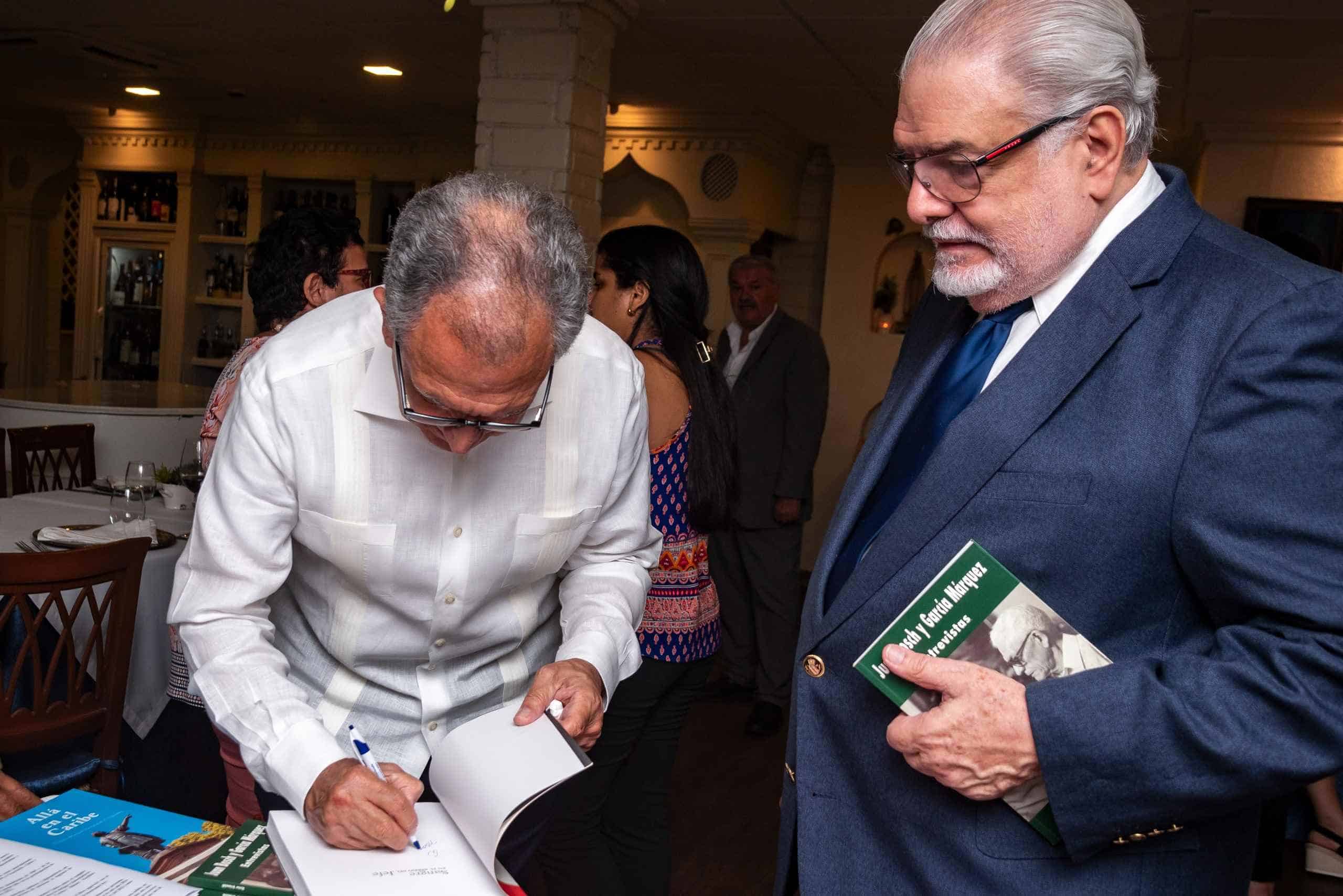 Víctor Grimaldi firma el libro adquirido por Manuel Morales Lama.