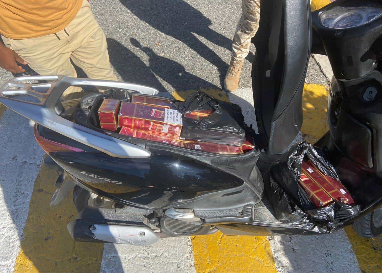 Imágenes de la incautación de la motocicleta con cigarrillos de contrabando.