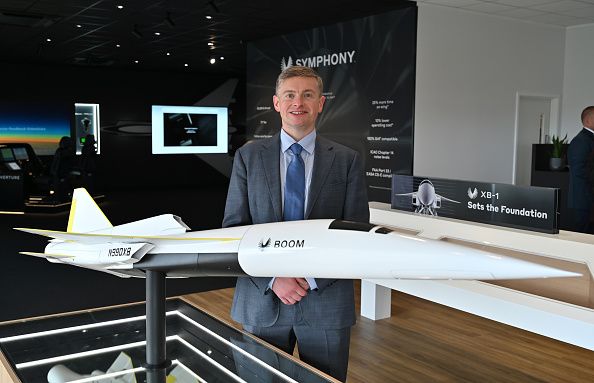 Blake Scholl, fundador y CEO de Boom, posa junto a una maqueta del XB-1