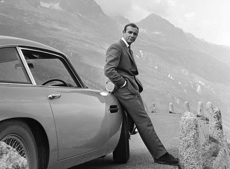 El actor Sean Connery posa como James Bond junto a su Aston Martin DB5 durante el rodaje de Goldfinger, Suiza, 1964.