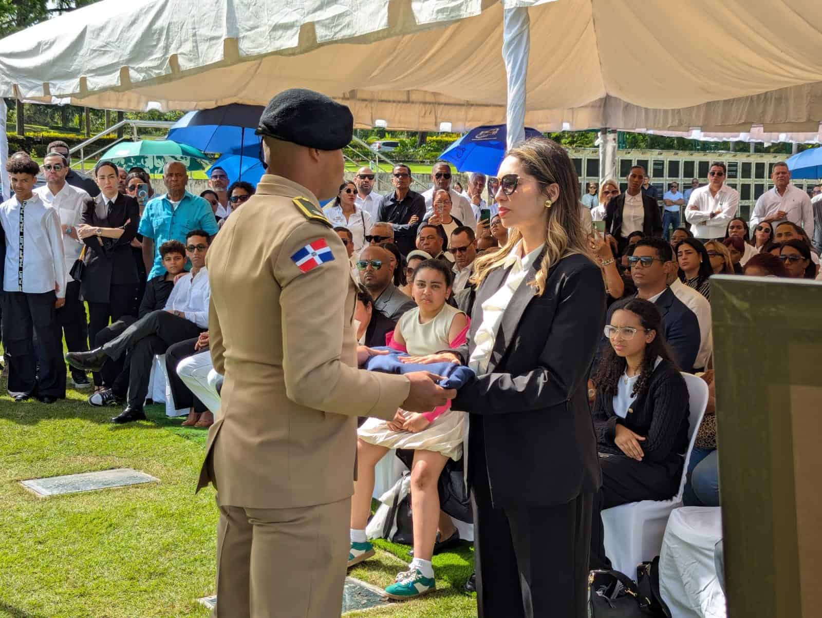Masiel Javier de Dotel recibe la bandera con la que se cubrió el féretro de su fenecido esposo, Octavio Dotel en el sepelio realizado este jueves 10 de abril de 2025 en el Cementerio Jardín Memorial.