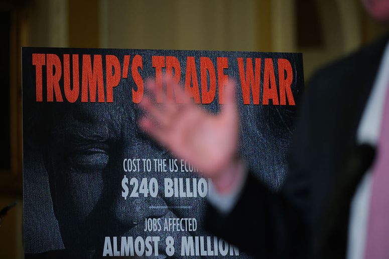 Un cartel sobre la guerra comercial de Trump detrás del senador estadounidense Tim Kaine (D-VA) mientras habla con los periodistas tras el almuerzo semanal de política del Senado demócrata en el Capitolio de Estados Unidos el 01 de abril de 2025 en Washington, DC. 