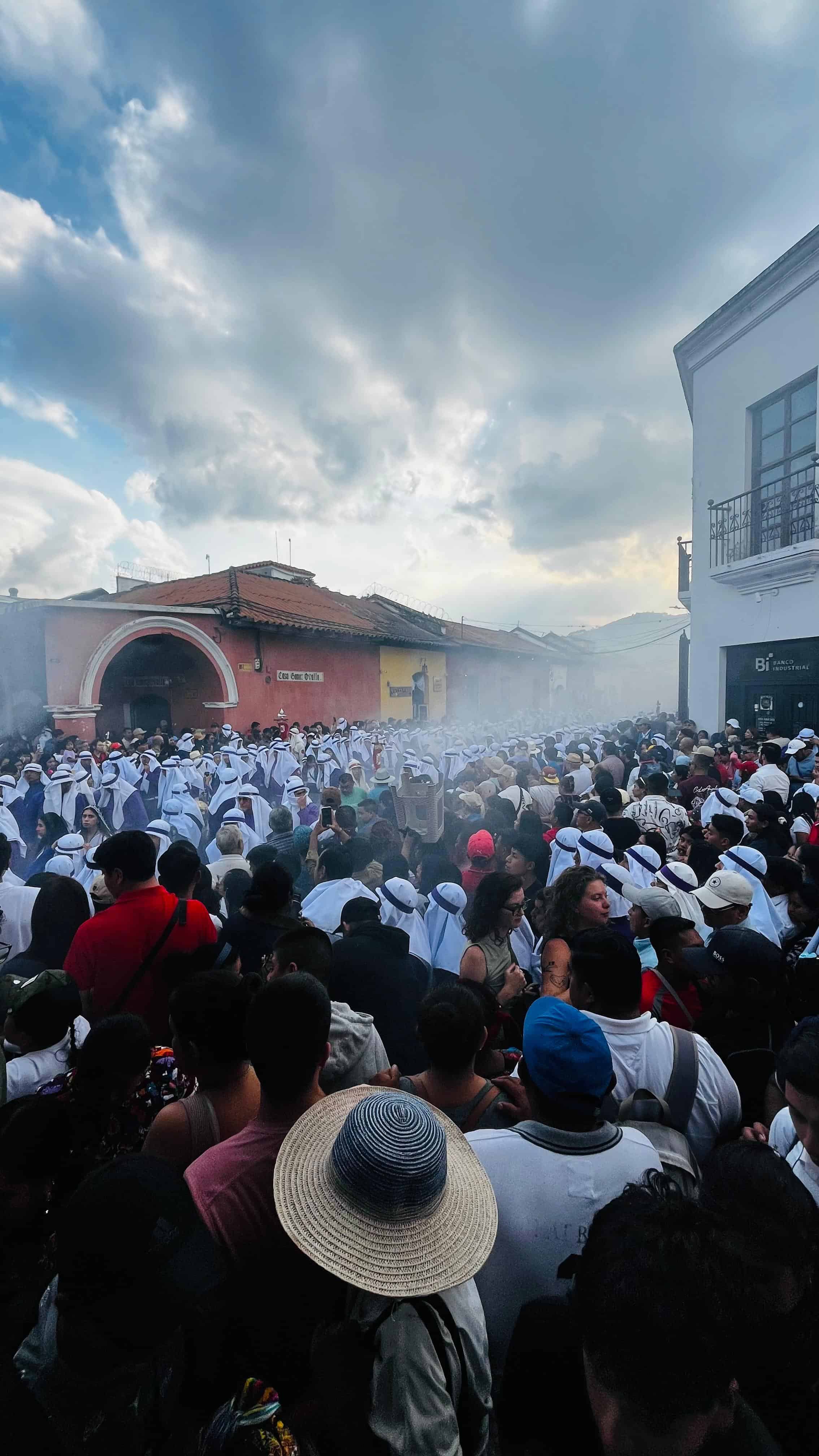 Los cucuruchos se pierden entre la multitud y el incienso.