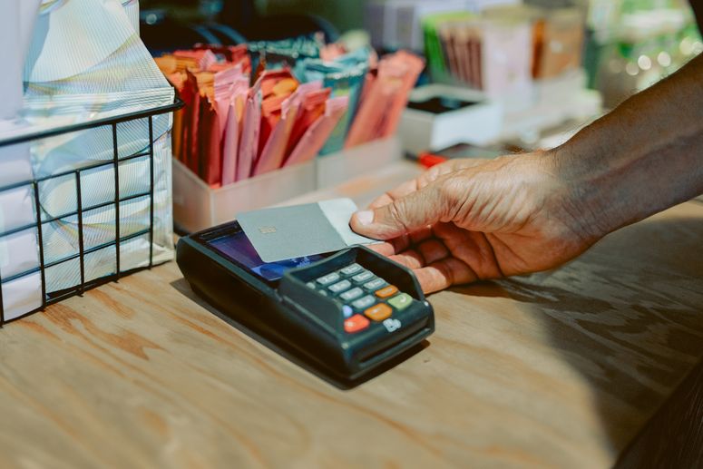 Un hombre utiliza una tarjeta de crédito para pagar con un lector de tarjetas. 