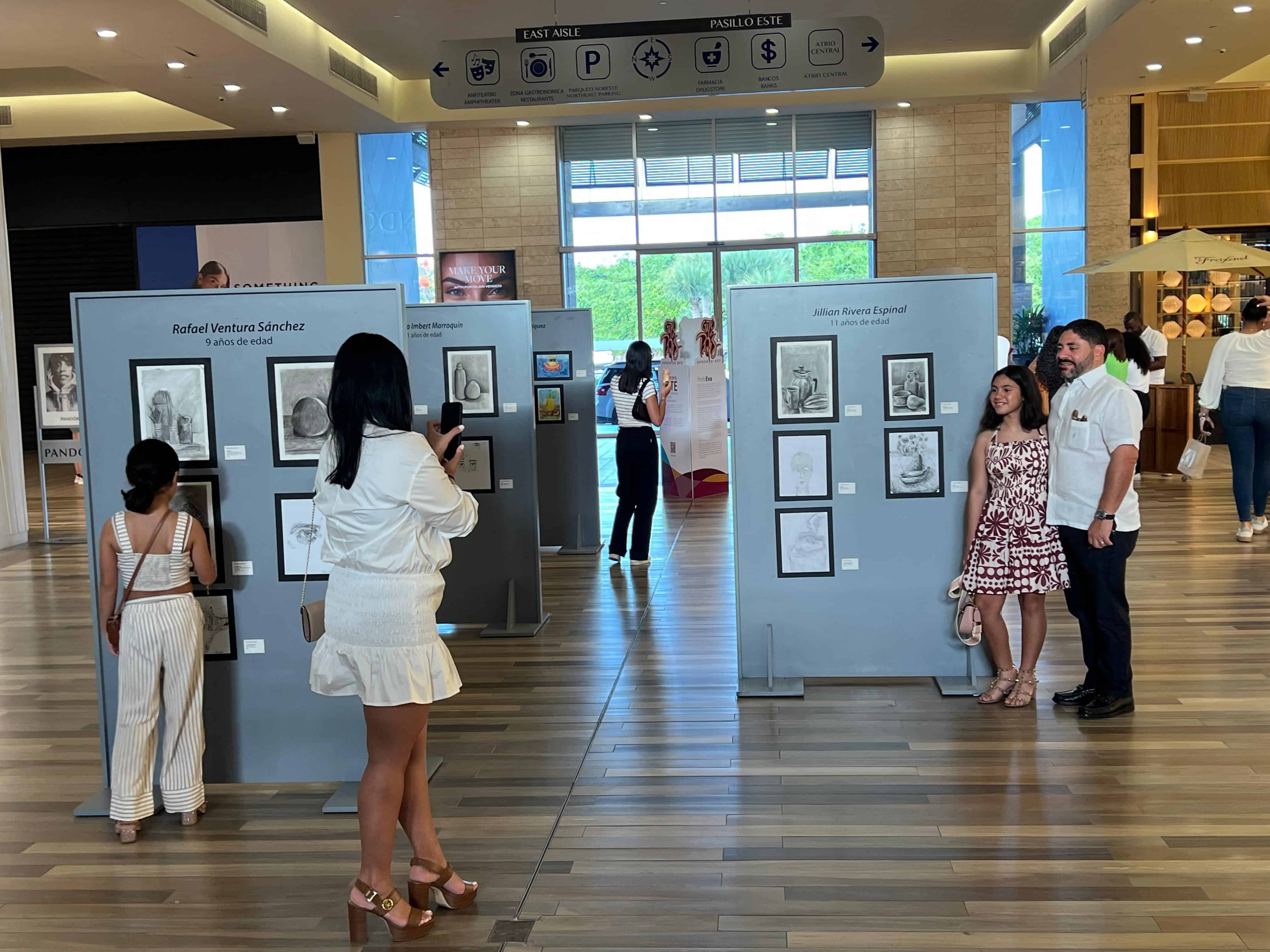 Participantes y familiares disfrutan de las obras durante la apertura de la exposición “Gato de París 2025” en BlueMall Puntacana.