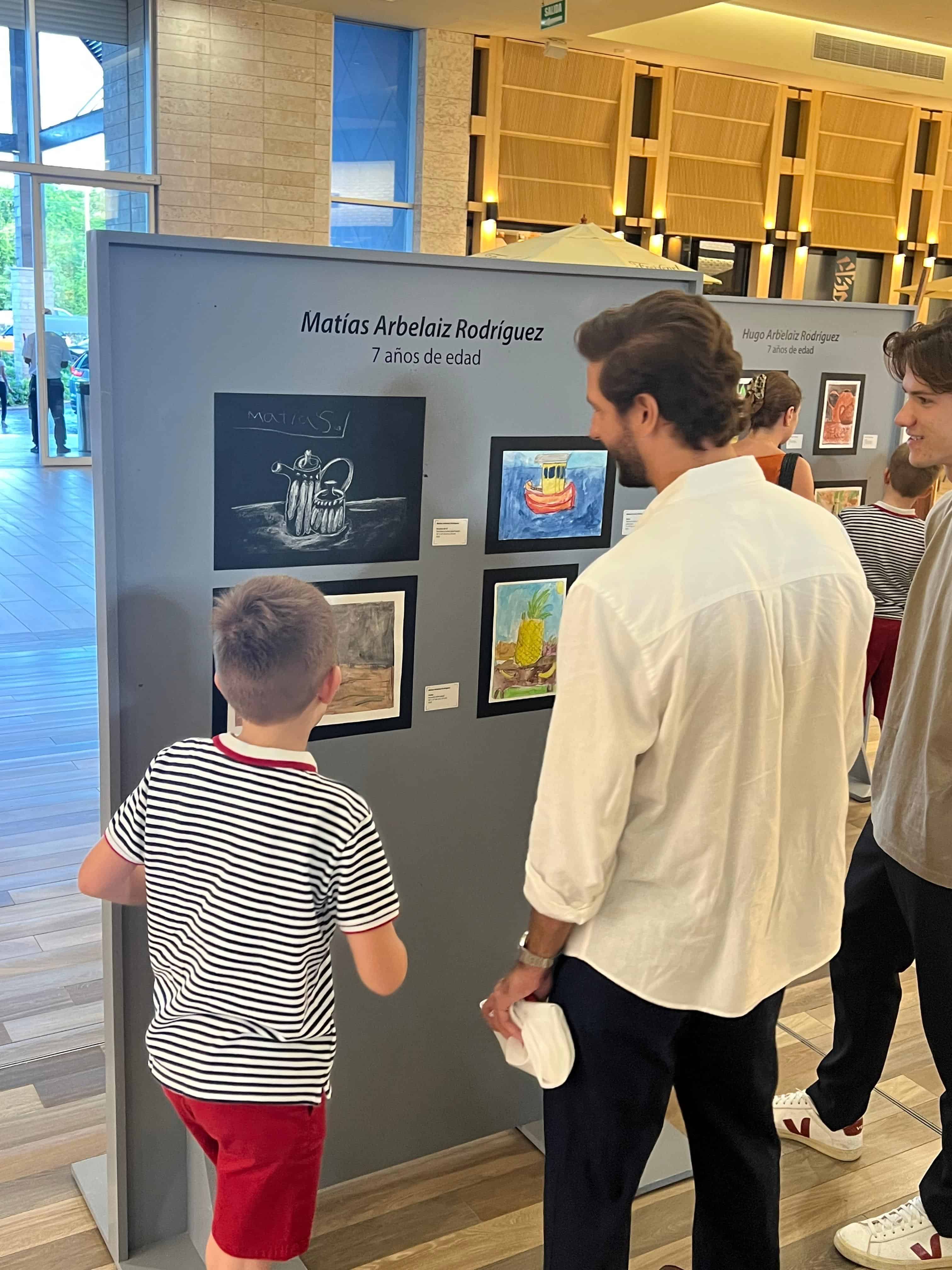Público y familiares recorren la sala de exposición, observando las piezas creadas por los estudiantes de Gato de París.