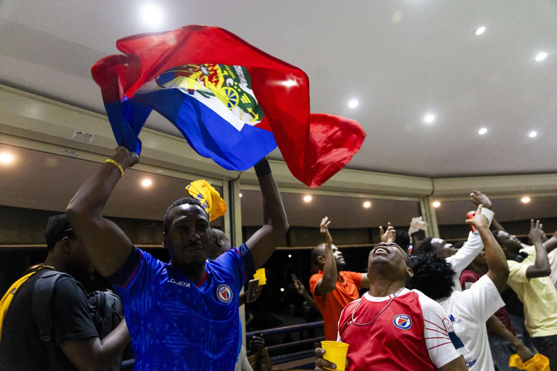 Con la bandera de Haití, aficionados celebran su clasificación al Mundial 2026.