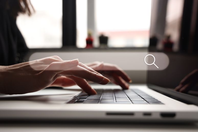 MANOS BUSCAN EN TECLADO DE LAPTOP